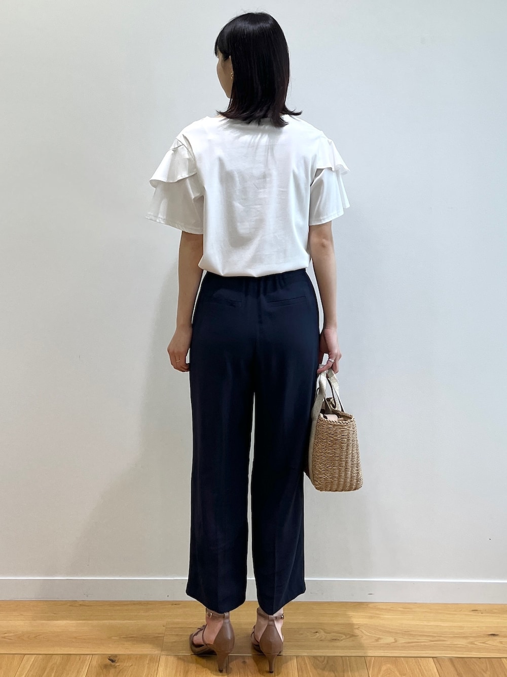 ブラウン系のサンダル、ホワイト系のTシャツ/カットソー、ゴールド系のトートバッグを着用したレディースの春コーディネートの3枚目の写真