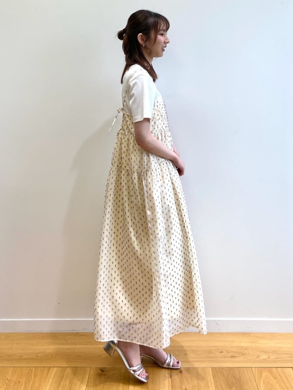 ホワイト系のワンピース、ホワイト系のTシャツ/カットソー、シルバー系のサンダルを着用したレディースの春コーディネートの2枚目の写真