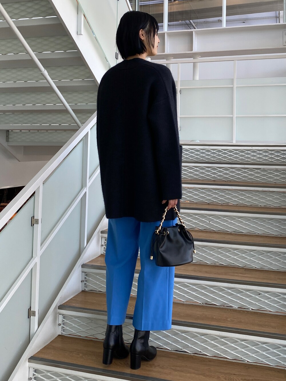 ホワイト系のニット/セーター、グレー系のカーディガン/ボレロ、ブルー系のその他パンツを着用したレディースの秋コーディネートの3枚目の写真