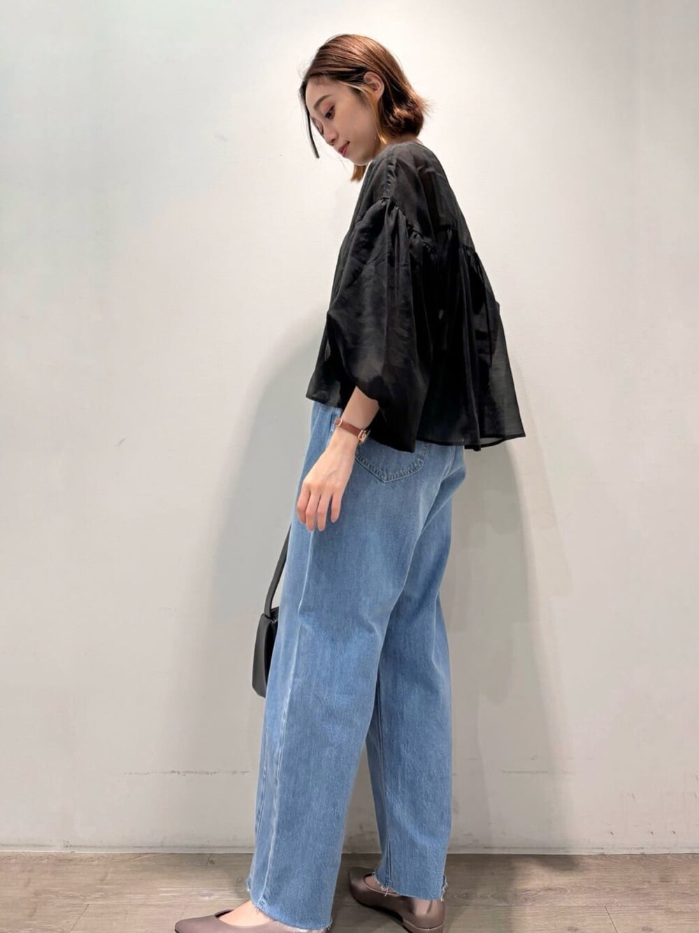 ブラック系のシャツ/ブラウス、シルバー系のパンプス、ブルー系のデニムパンツを着用したレディースの夏コーディネートの5枚目の写真