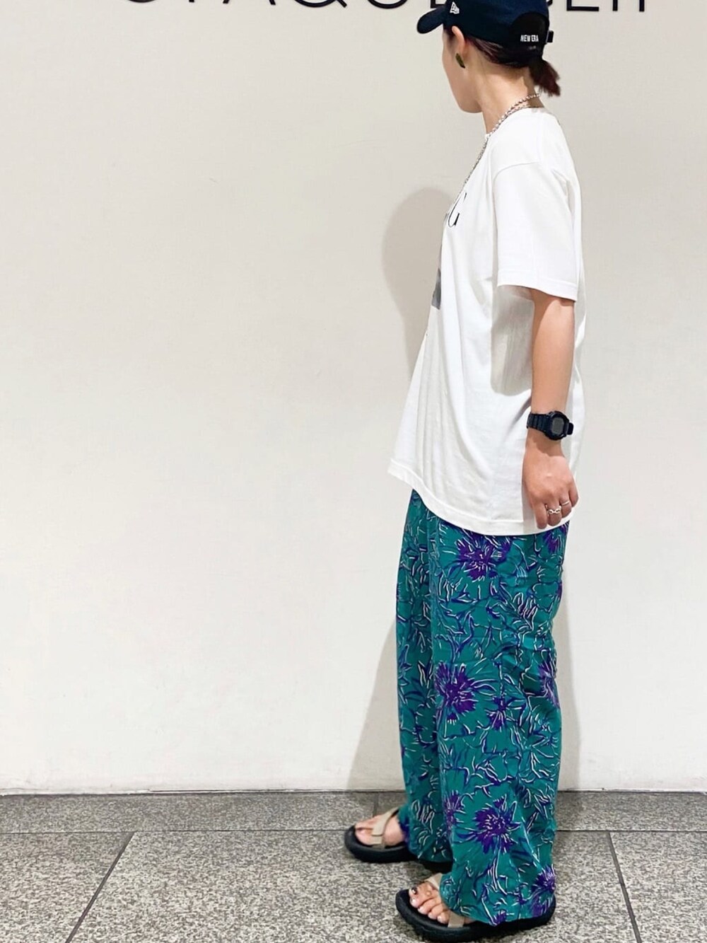 グレー系のショルダーバッグ、グリーン系のその他パンツ、ホワイト系のTシャツ/カットソーを着用したレディースの夏コーディネートの4枚目の写真