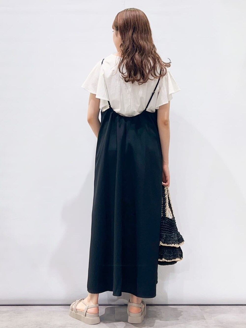ブラック系のワンピース、ホワイト系のTシャツ/カットソー、ブラック系のトートバッグを着用したレディースの夏コーディネートの3枚目の写真