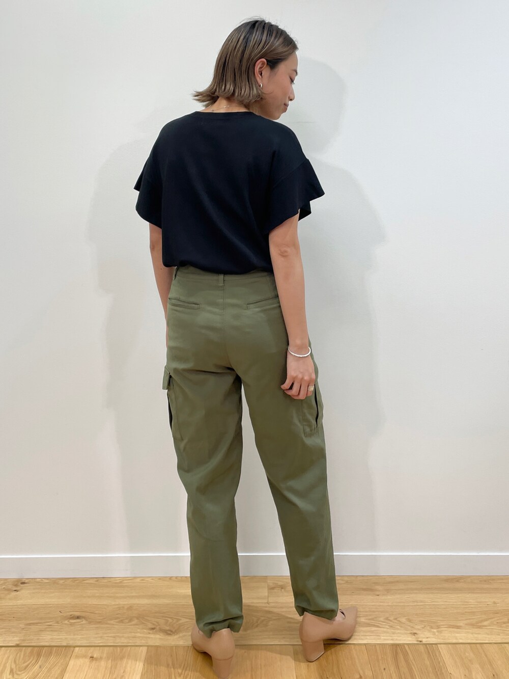 ブラック系のニット/セーター、グリーン系のその他パンツ、ベージュ系のパンプスを着用したレディースの夏コーディネートの3枚目の写真