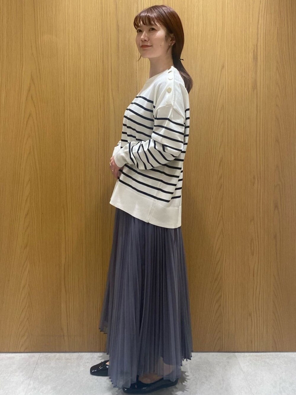 ホワイト系のニット/セーター、グレー系のスカート、ホワイト系のショルダーバッグを着用したレディースの冬コーディネートの2枚目の写真