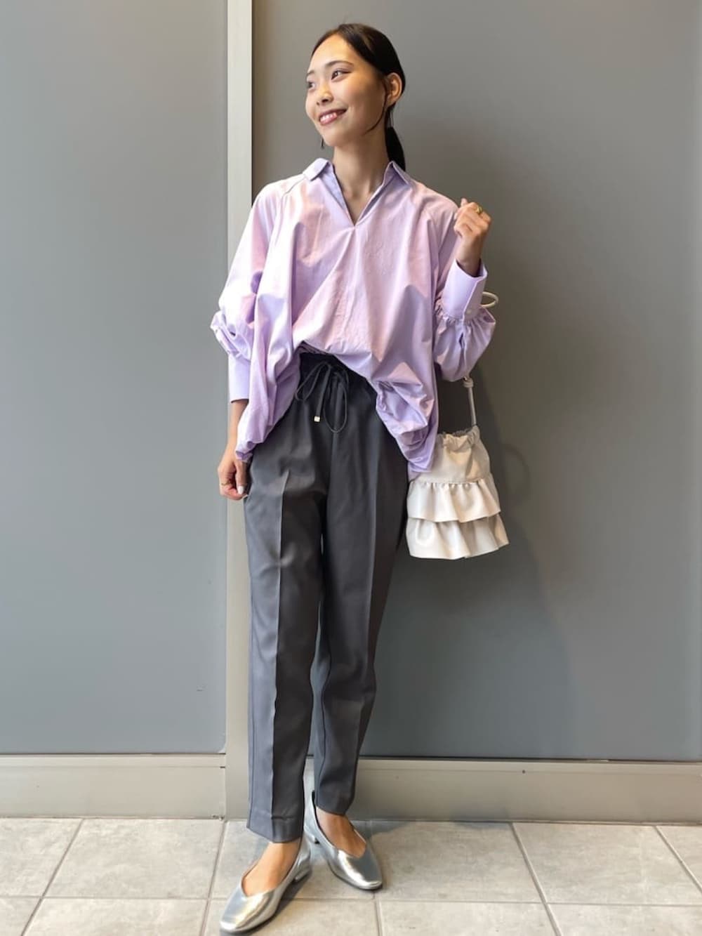 パープル系のシャツ/ブラウス、グレー系のその他パンツ、ホワイト系のショルダーバッグを着用したレディースの秋コーディネートの2枚目の写真
