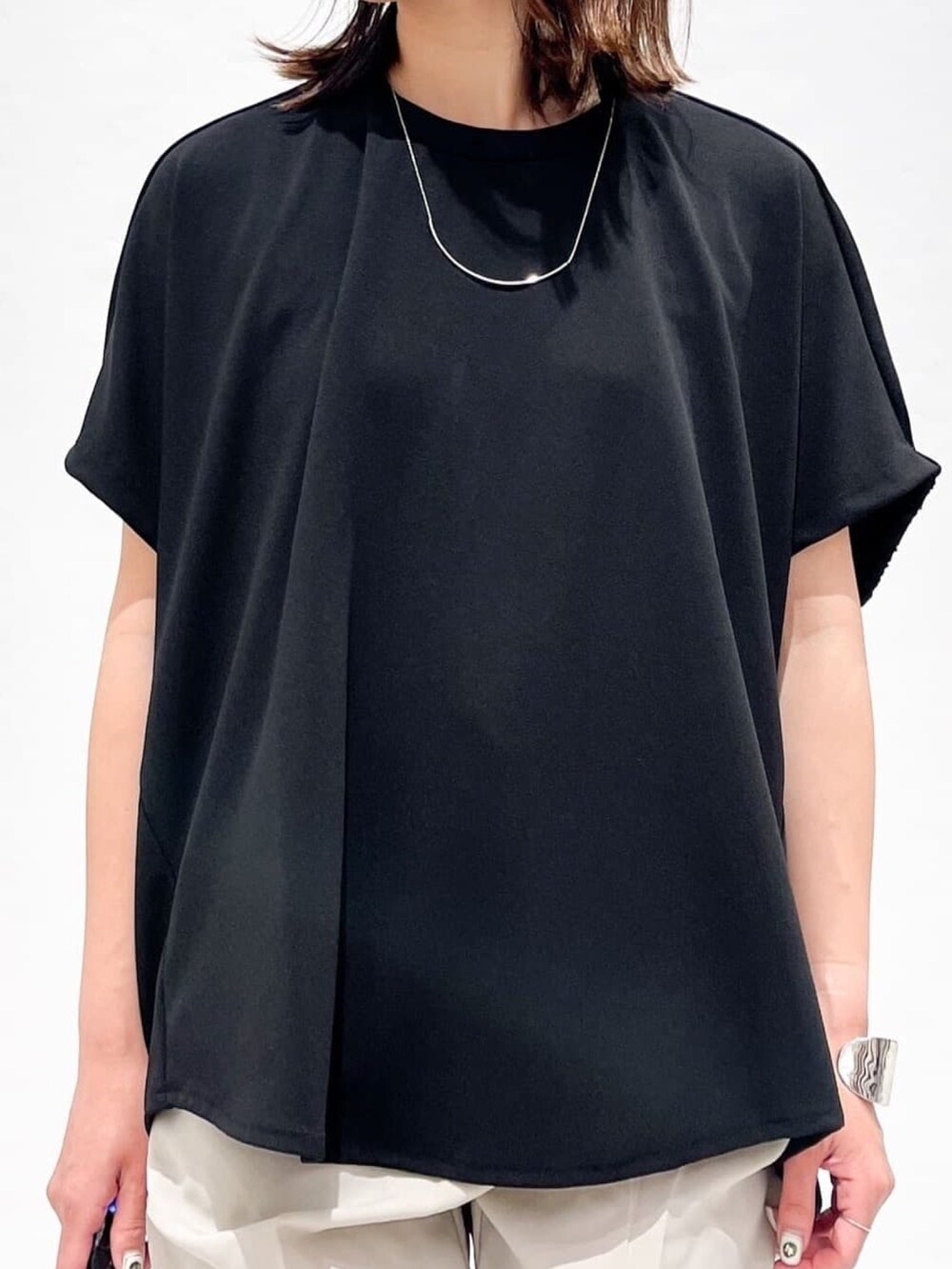 ブラック系のTシャツ/カットソー、グレー系のその他パンツ、シルバー系のサンダルを着用したレディースの春コーディネートの8枚目の写真