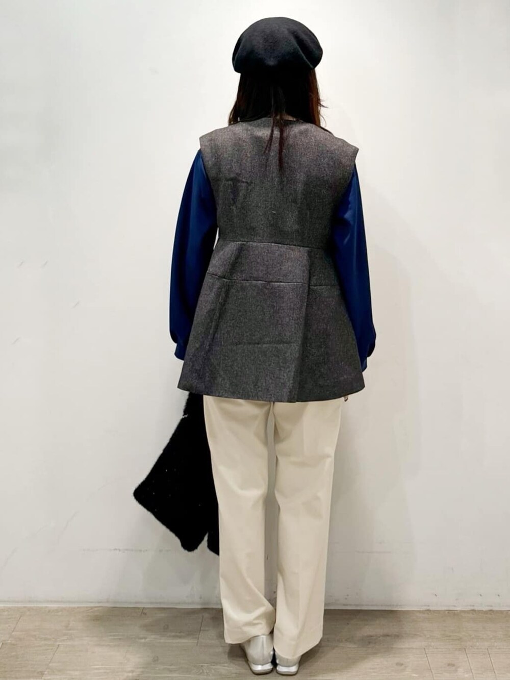 ブラック系のハンドバッグ、ホワイト系のその他パンツ、グレー系のベストを着用したレディースの秋コーディネートの6枚目の写真