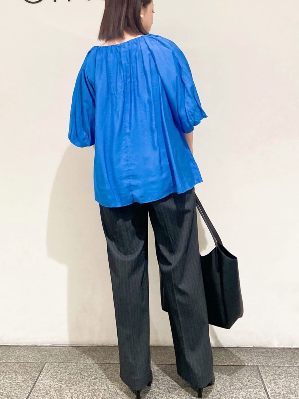 ブルー系のシャツ/ブラウス、グレー系のその他パンツ、ブラック系のトートバッグを着用したレディースの夏コーディネートの5枚目の写真