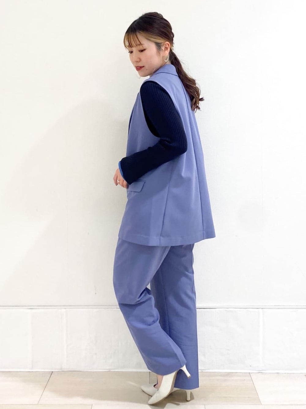 ブルー系のベスト、ブルー系のその他パンツ、ホワイト系のパンプスを着用したレディースの春コーディネートの2枚目の写真