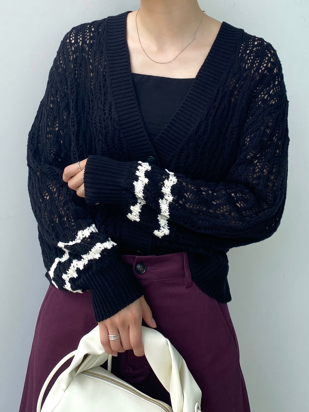 ブラック系のカーディガン/ボレロ、ホワイト系のショルダーバッグ、パープル系のスカートを着用したレディースの夏コーディネートの3枚目の写真