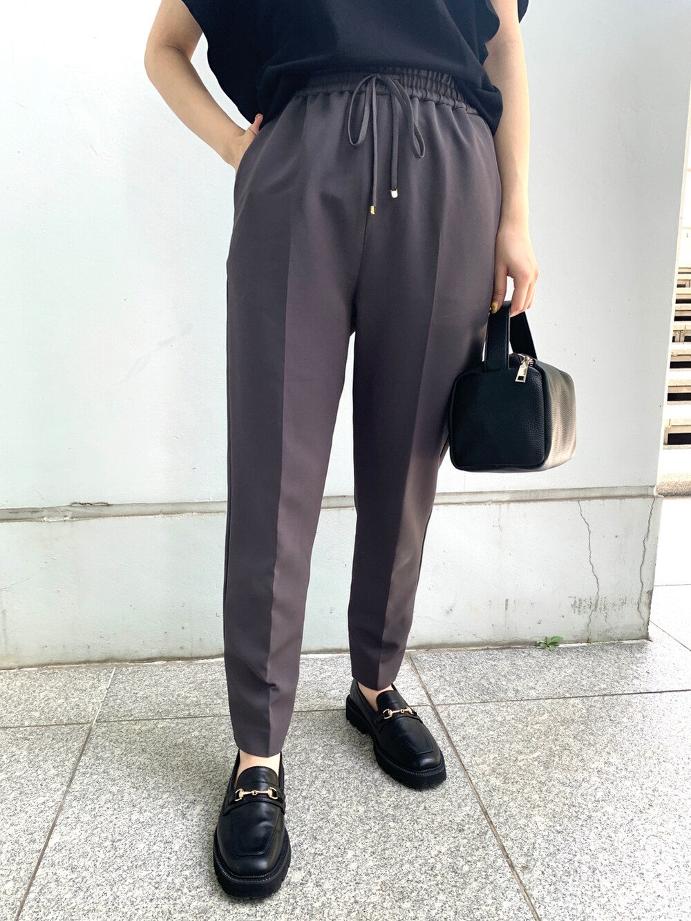 ブラック系のニット/セーター、ブラック系のその他パンツ、ブラック系のシューズを着用したレディースの夏コーディネートの5枚目の写真