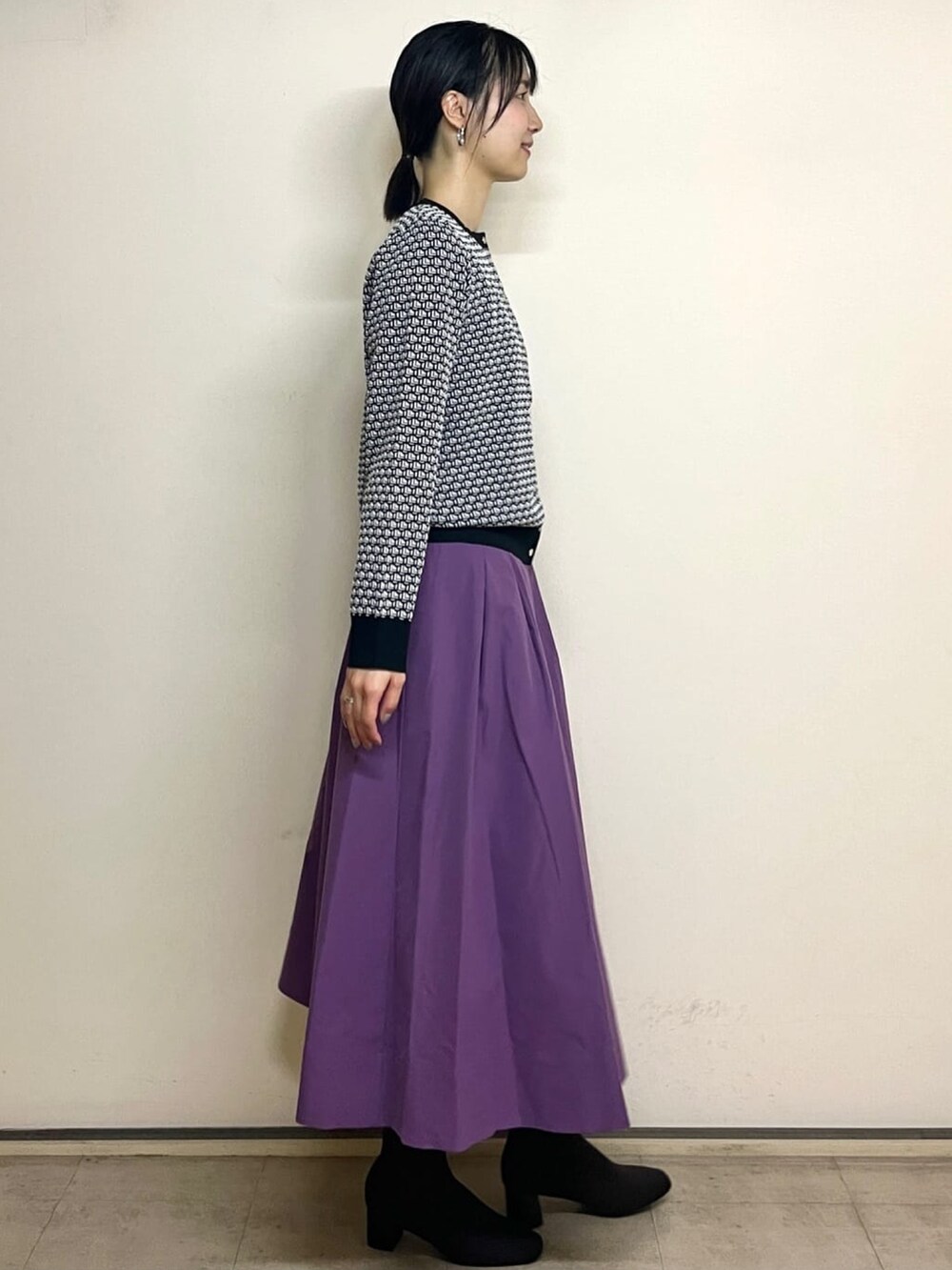 ホワイト系のカーディガン/ボレロ、パープル系のスカート、ブラック系のブーツを着用したレディースの夏コーディネートの3枚目の写真