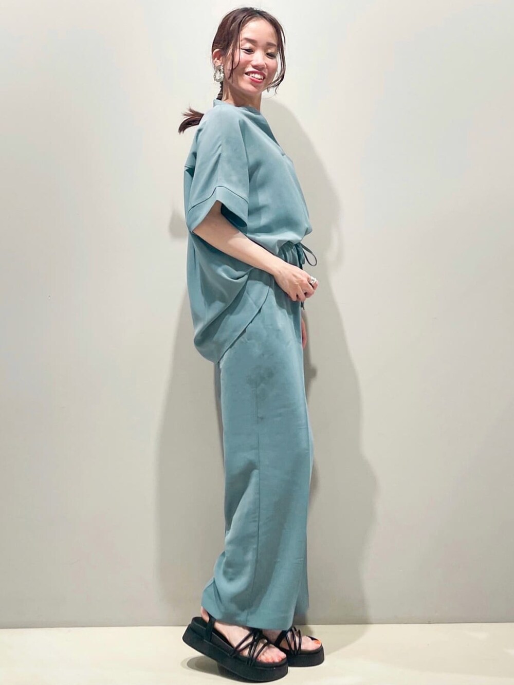 ブルー系のシャツ/ブラウス、ブラック系のサンダル、ブラック系のショルダーバッグを着用したレディースの夏コーディネートの2枚目の写真