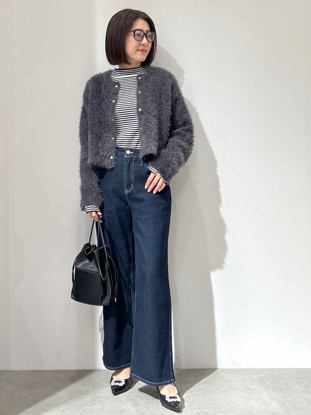 グレー系のカーディガン/ボレロ、ブルー系のその他パンツ、ブラック系のショルダーバッグを着用したレディースの冬コーディネートの2枚目の写真