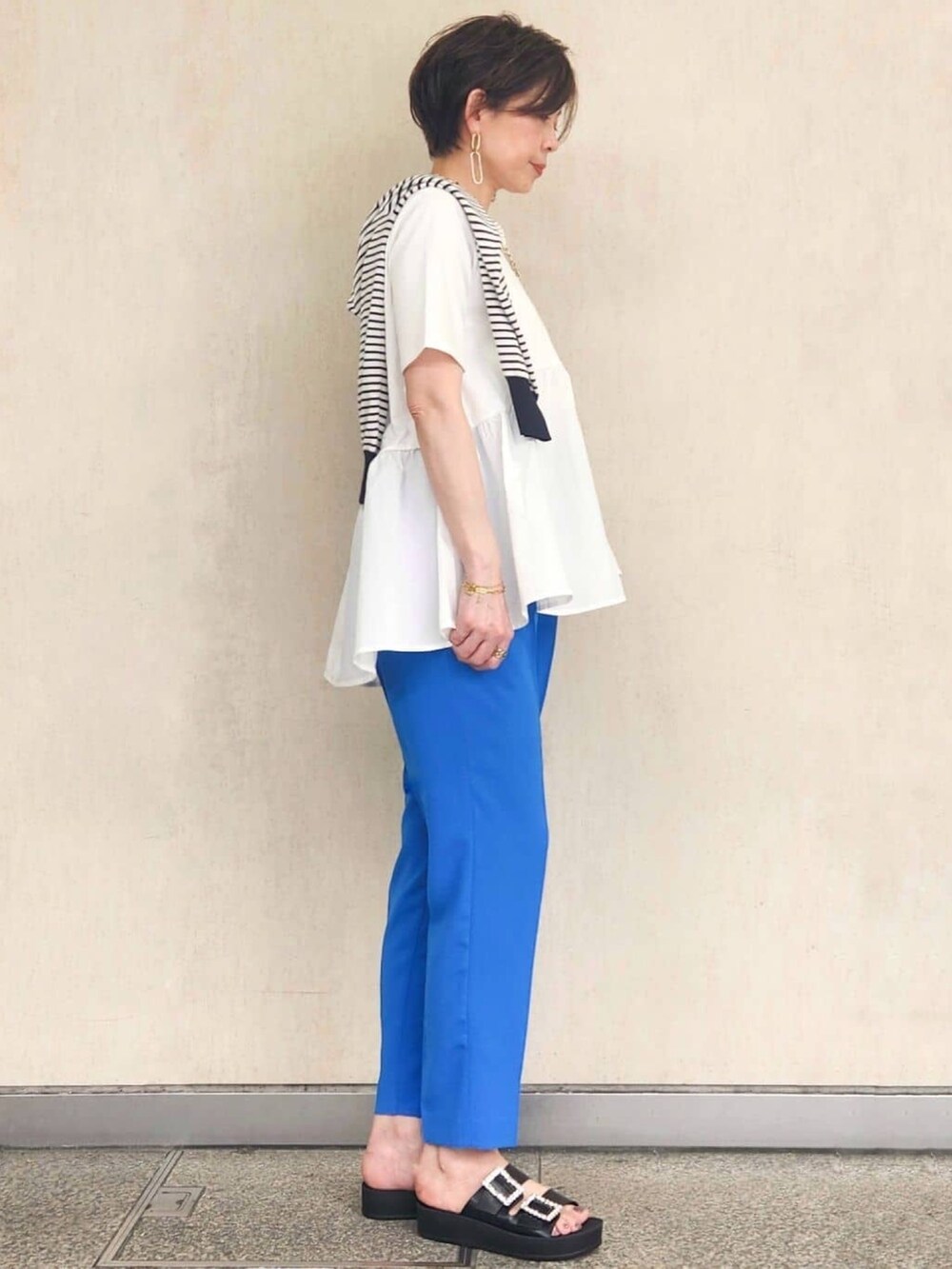 ブルー系のその他パンツ、ブラック系のサンダル、ホワイト系のTシャツ/カットソーを着用したレディースの春コーディネートの3枚目の写真