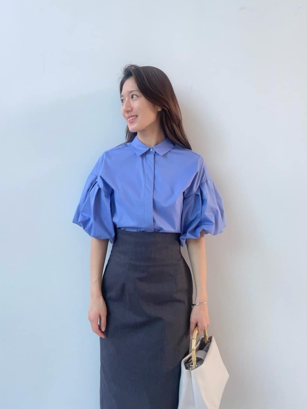 ブルー系のシャツ/ブラウス、ブラック系のスカート、シルバー系のサンダルを着用したレディースの春コーディネートの2枚目の写真