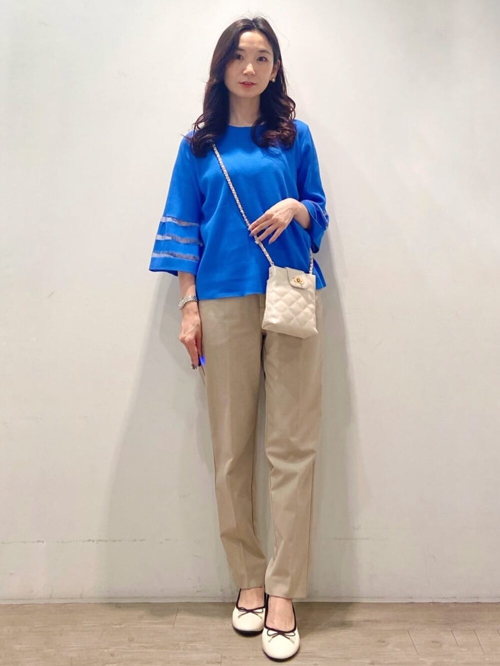 ベージュ系のその他パンツ、ブルー系のニット/セーターを着用したレディースの春コーディネートの3枚目の写真