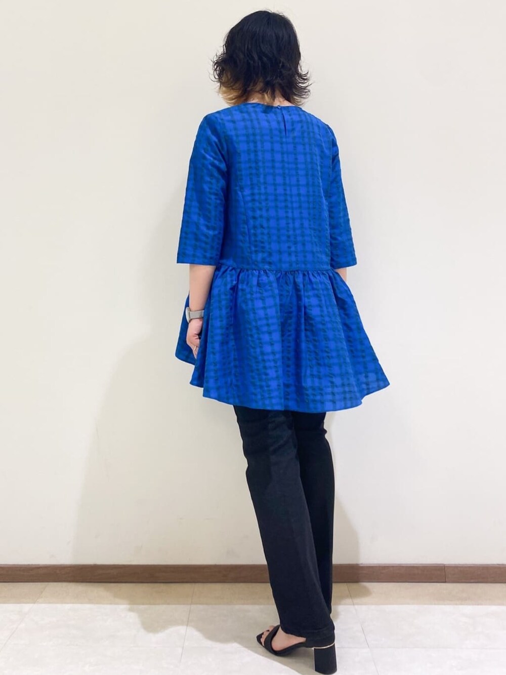 ブラック系のサンダル、ブルー系のチュニック、グレー系のデニムパンツを着用したレディースの夏コーディネートの3枚目の写真