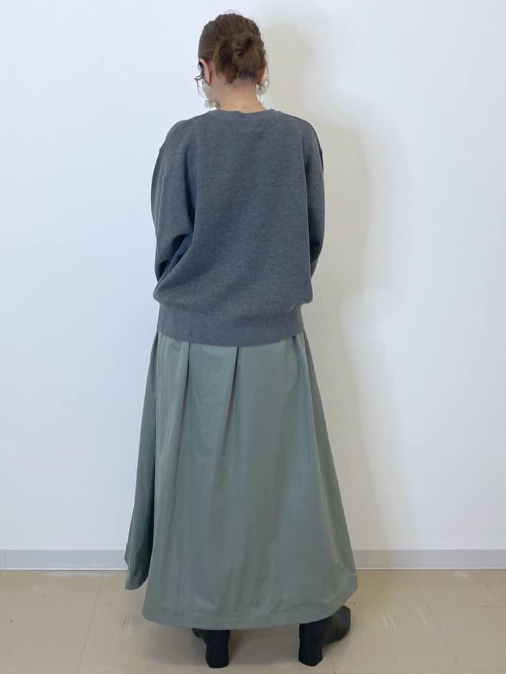 グレー系のニット/セーター、グリーン系のスカート、ホワイト系のショルダーバッグを着用したレディースの冬コーディネートの4枚目の写真