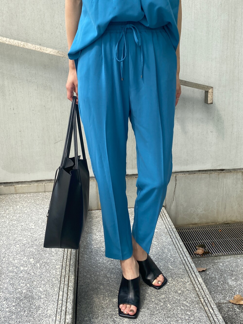 ブルー系のシャツ/ブラウス、ブルー系のその他パンツ、ブラック系のトートバッグを着用したレディースの夏コーディネートの5枚目の写真