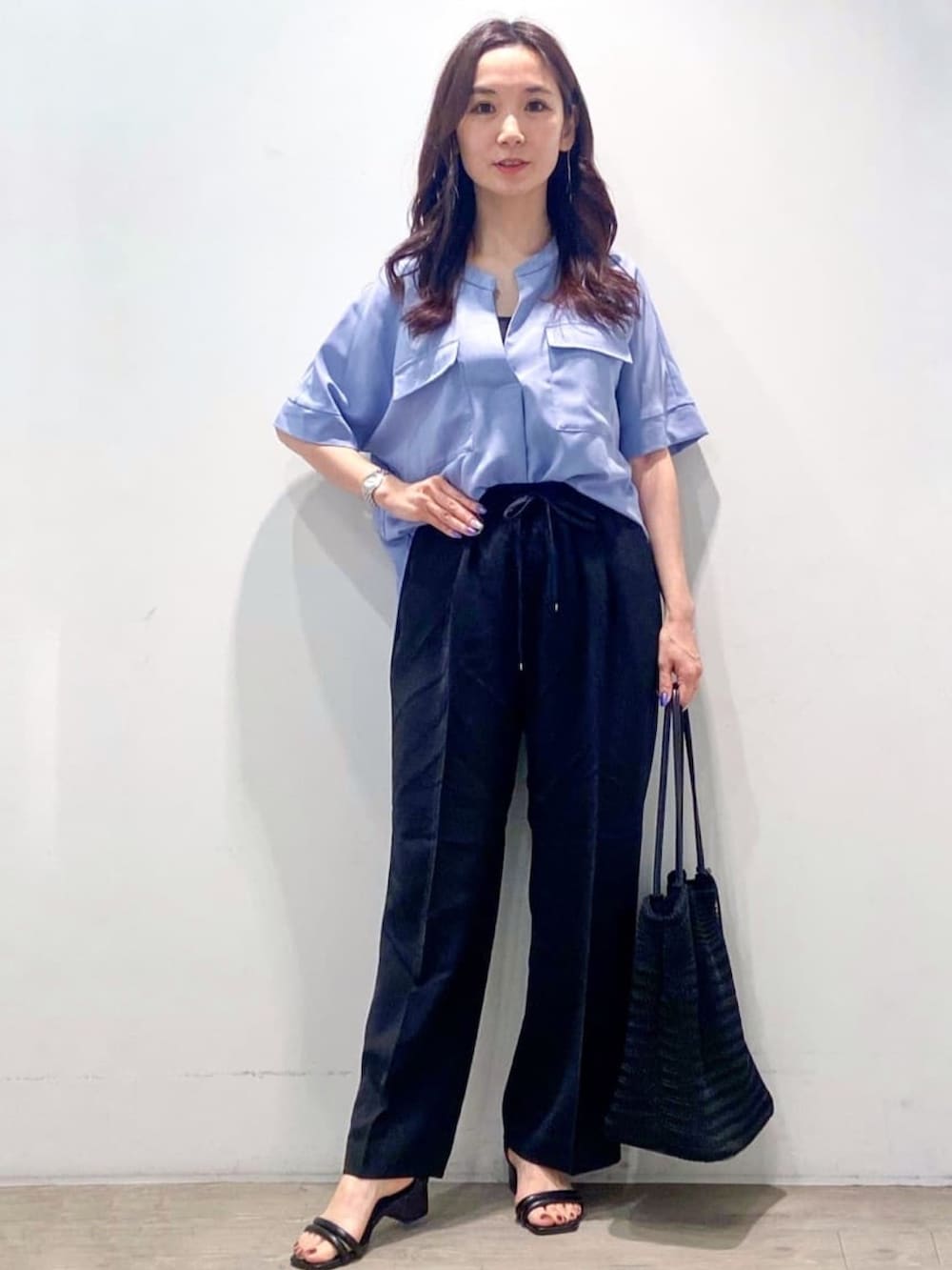 ブルー系のシャツ/ブラウス、ブラック系のその他パンツ、ブラック系のトートバッグを着用したレディースの春コーディネートの4枚目の写真
