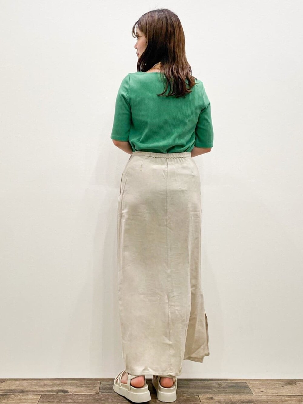 ベージュ系のスカート、ベージュ系のテーラードジャケット、グリーン系のTシャツ/カットソーを着用したレディースの春コーディネートの4枚目の写真