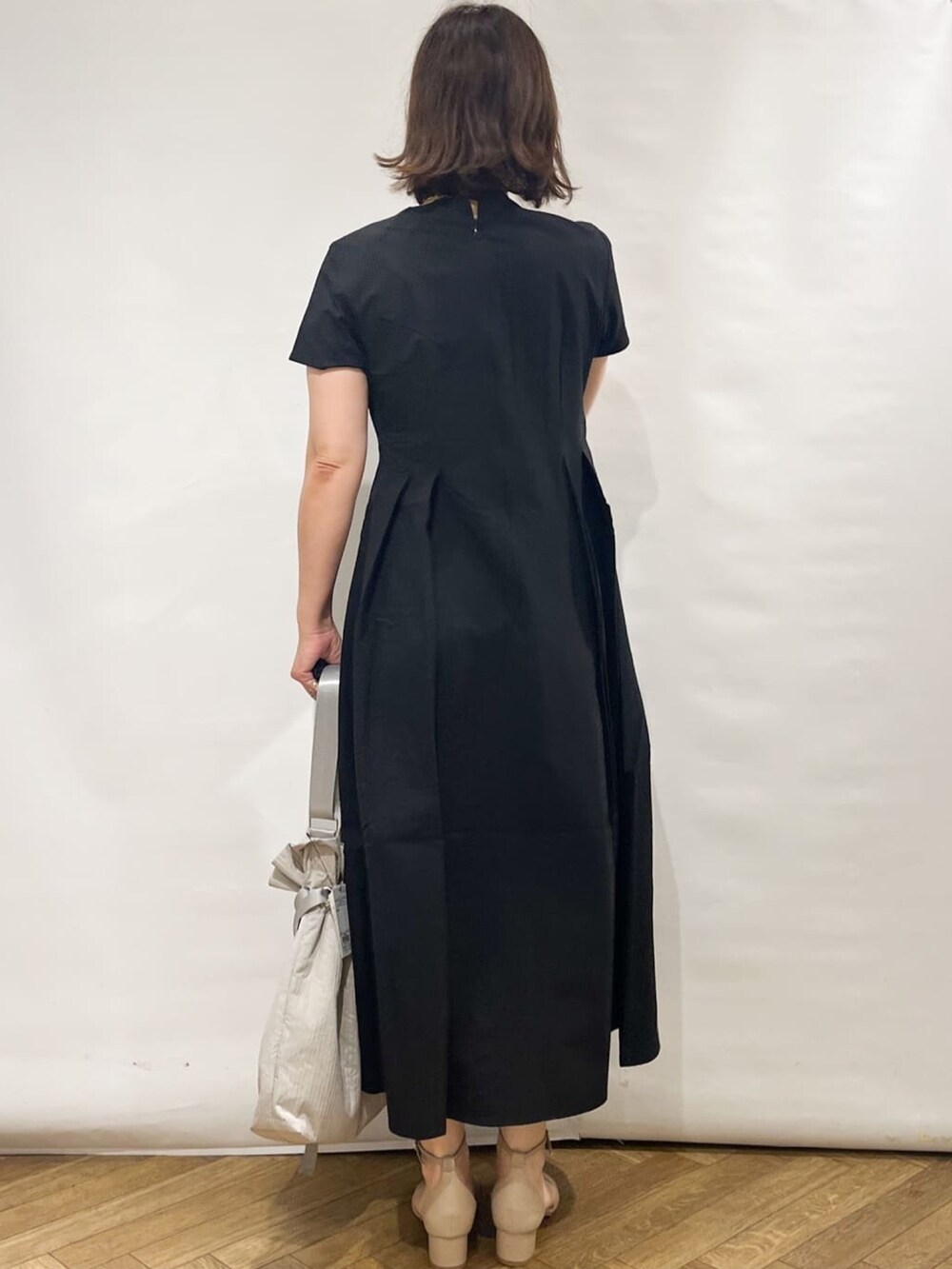 ブラック系のワンピース、ホワイト系のカーディガン/ボレロ、ホワイト系のトートバッグを着用したレディースの夏コーディネートの5枚目の写真