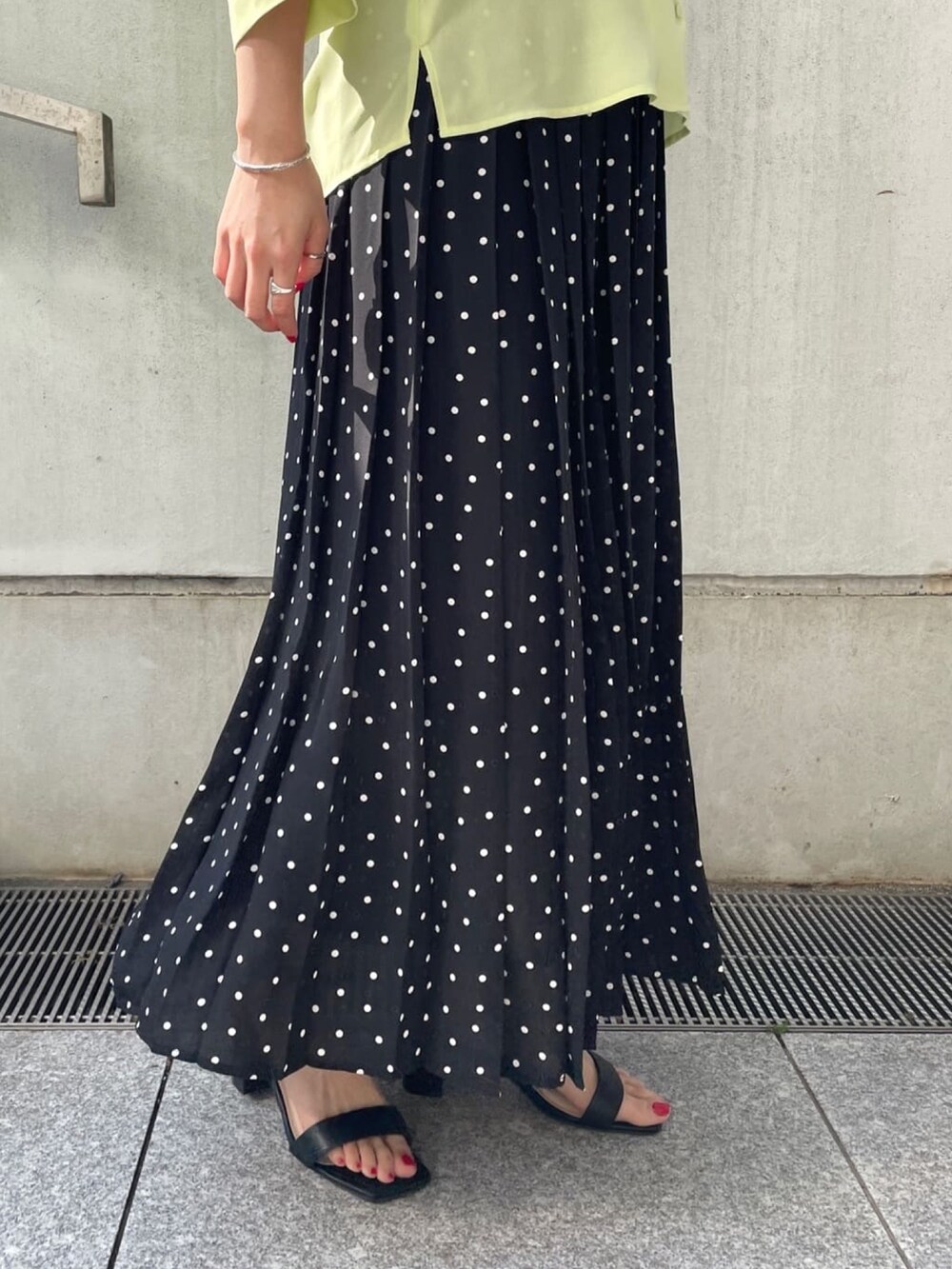 グリーン系のシャツ/ブラウス、ブラック系のスカート、ブラック系のサンダルを着用したレディースの春コーディネートの7枚目の写真