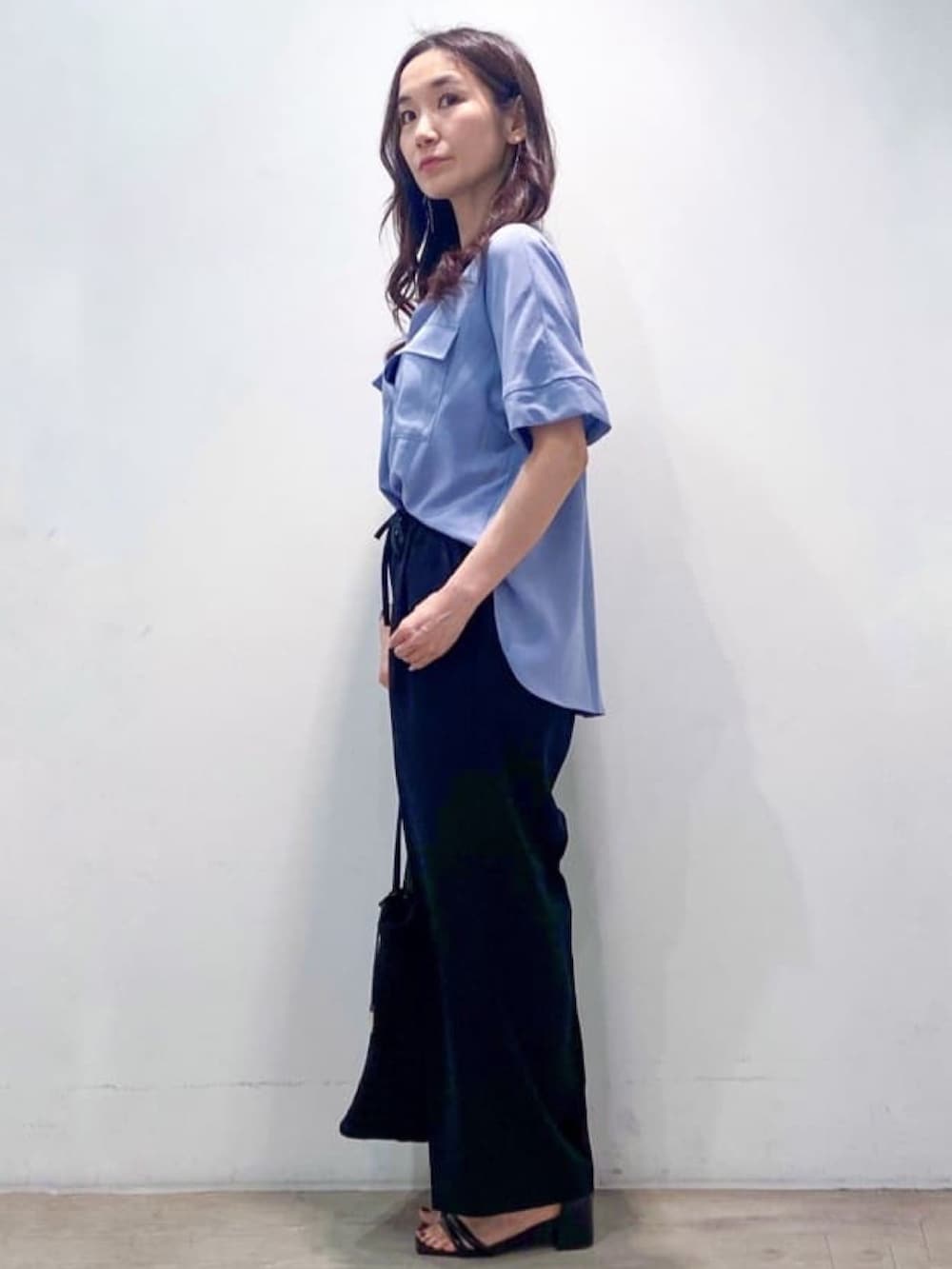 ブルー系のシャツ/ブラウス、ブラック系のその他パンツ、ブラック系のトートバッグを着用したレディースの春コーディネートの7枚目の写真