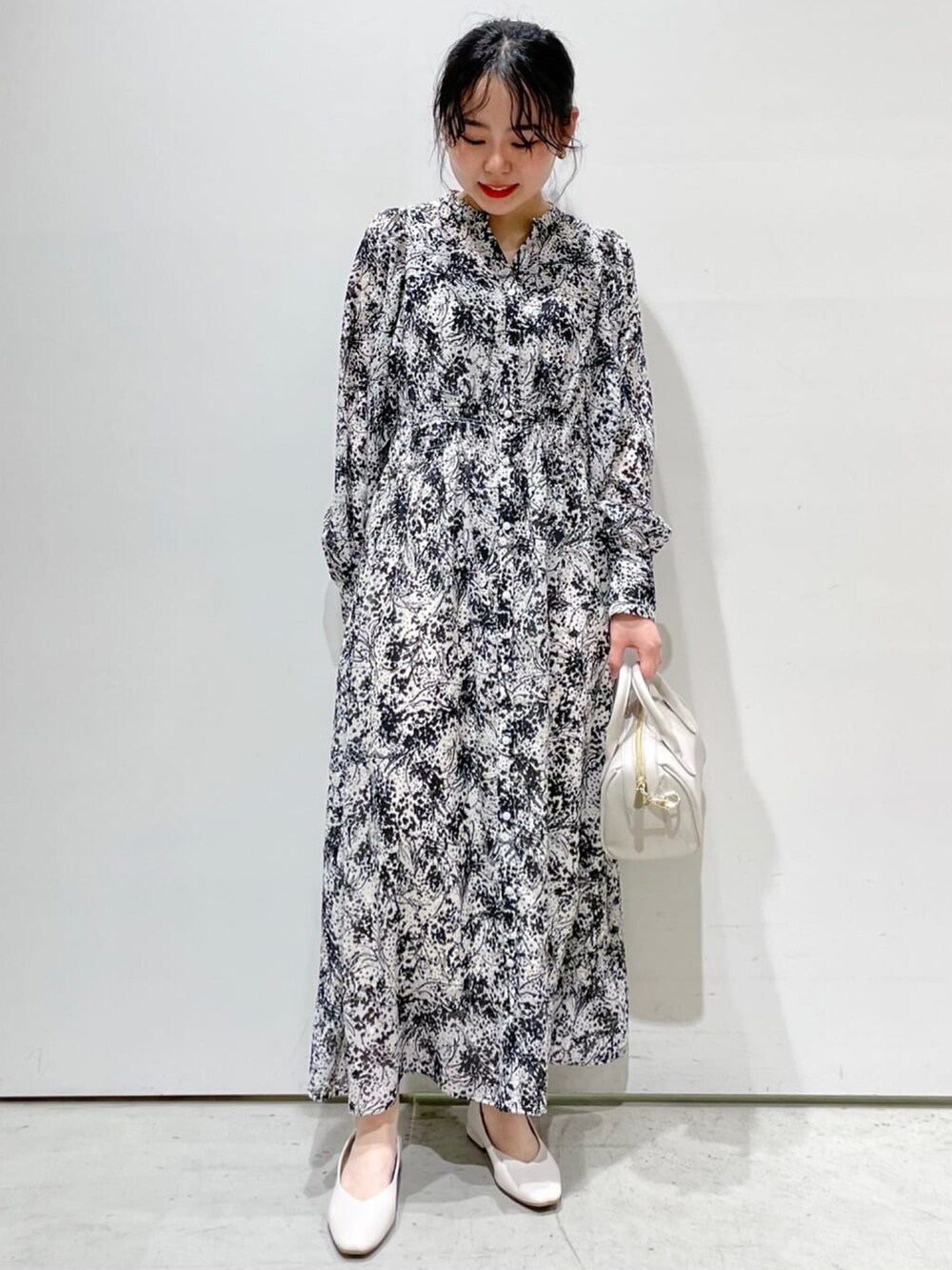 ブルー系のノーカラーコート、ブラック系のワンピース、ホワイト系のパンプスを着用したレディースの春コーディネートの3枚目の写真