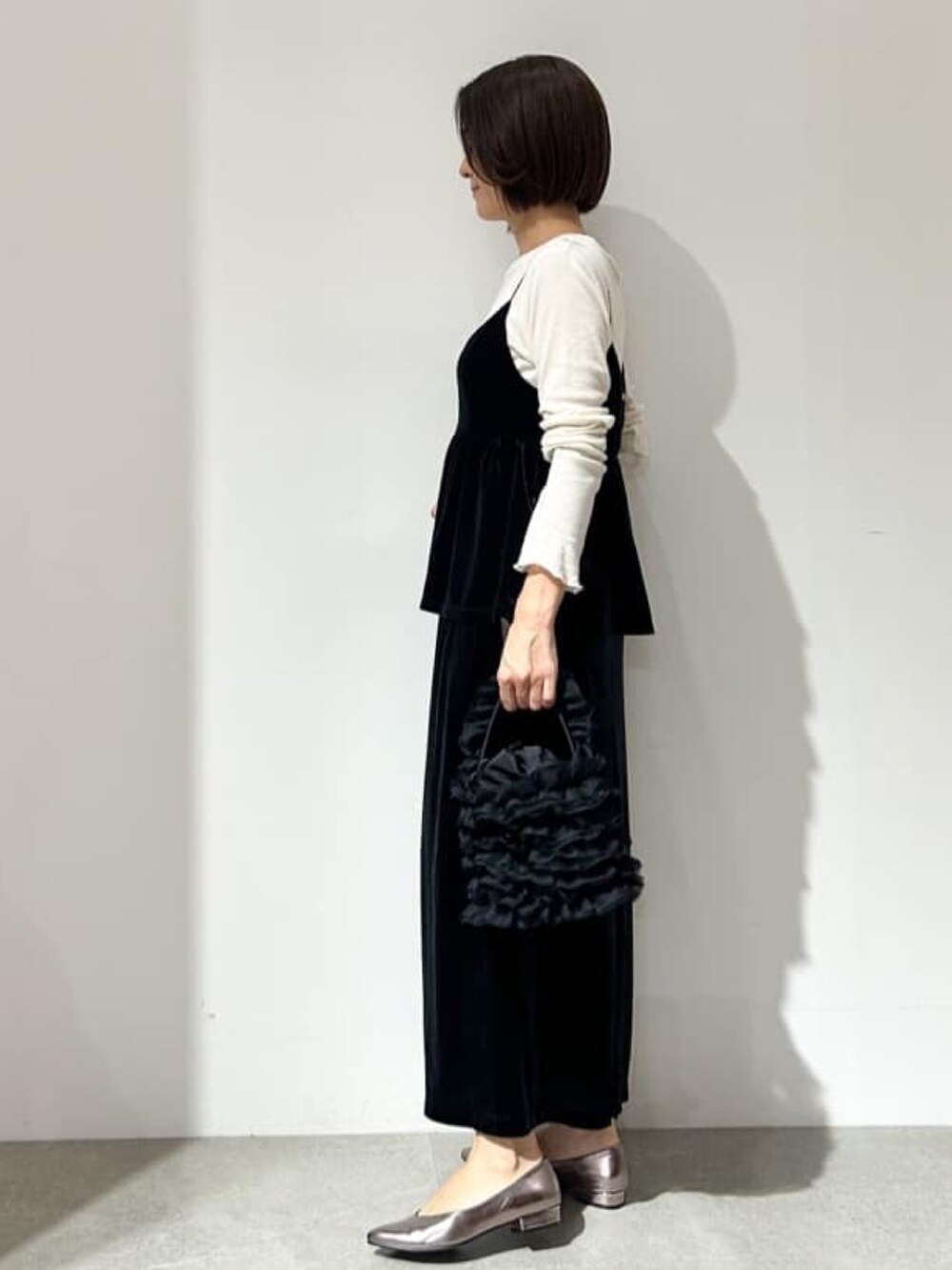 ブラック系のスカート、ブラック系のタンクトップ、ホワイト系のTシャツ/カットソーを着用したレディースの秋コーディネートの2枚目の写真