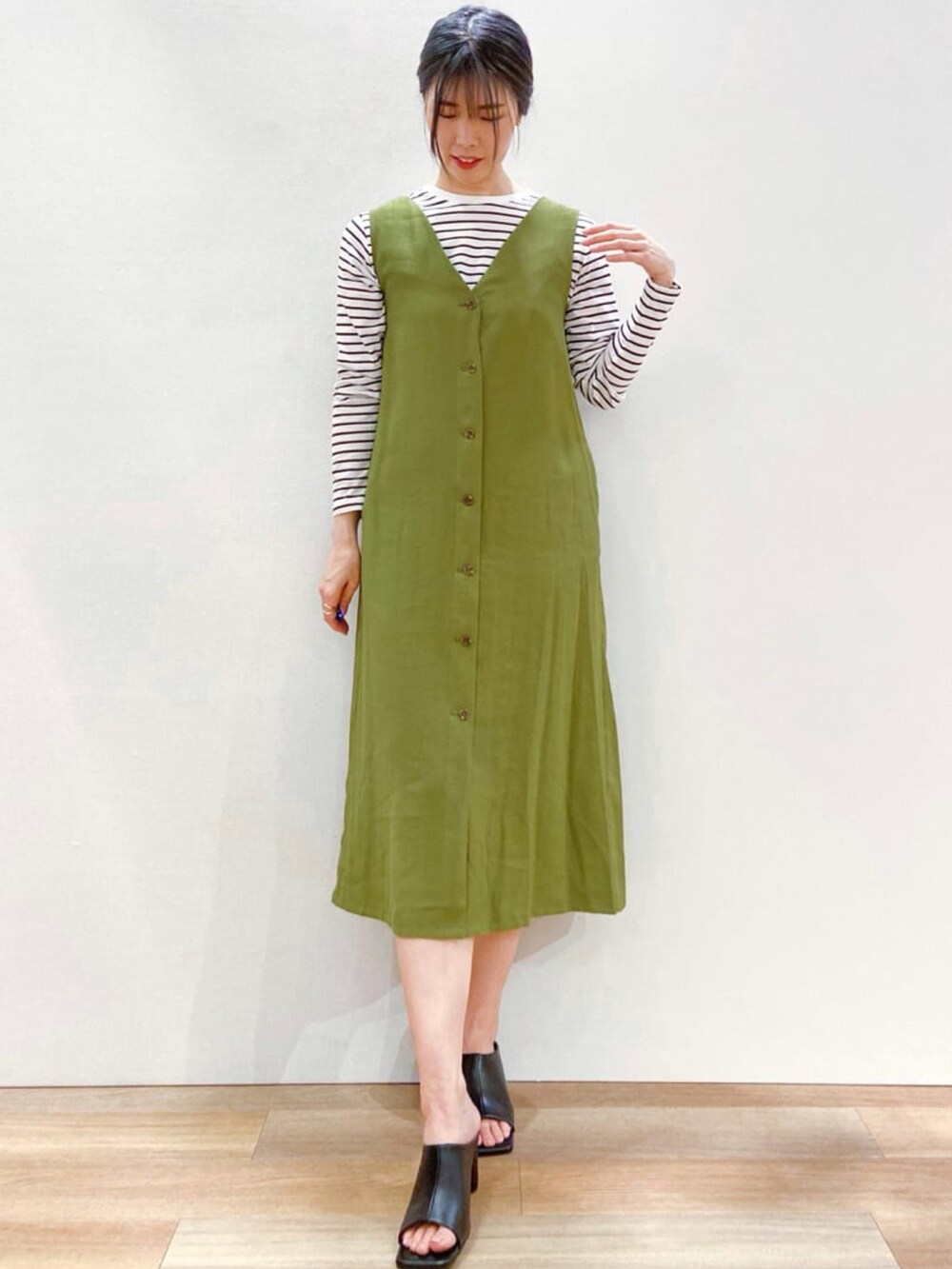 グリーン系のスカート、ホワイト系のTシャツ/カットソー、ブラック系のトートバッグを着用したレディースの春コーディネートの2枚目の写真