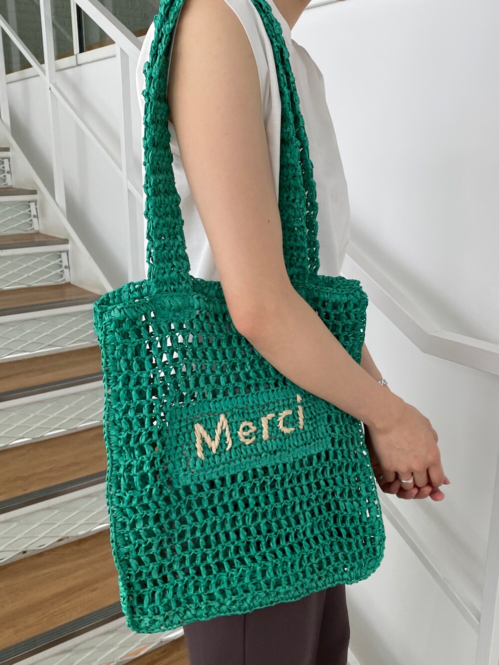 ホワイト系のTシャツ/カットソー、ブラウン系のその他パンツ、グリーン系のトートバッグを着用したレディースの春コーディネートの3枚目の写真