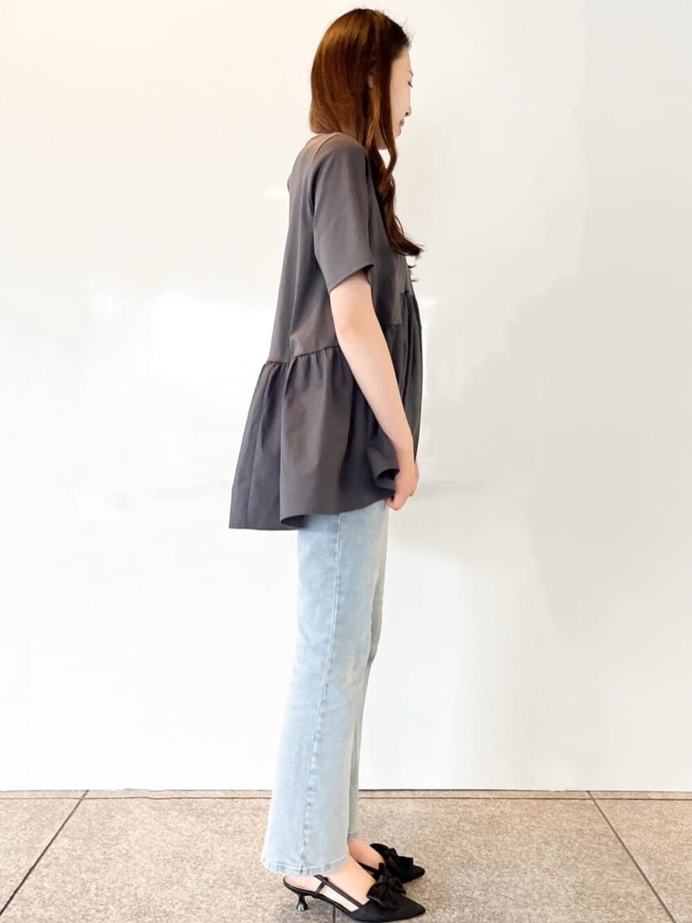 グレー系のTシャツ/カットソー、ブルー系のデニムパンツ、ブラック系のパンプスを着用したレディースの春コーディネートの4枚目の写真