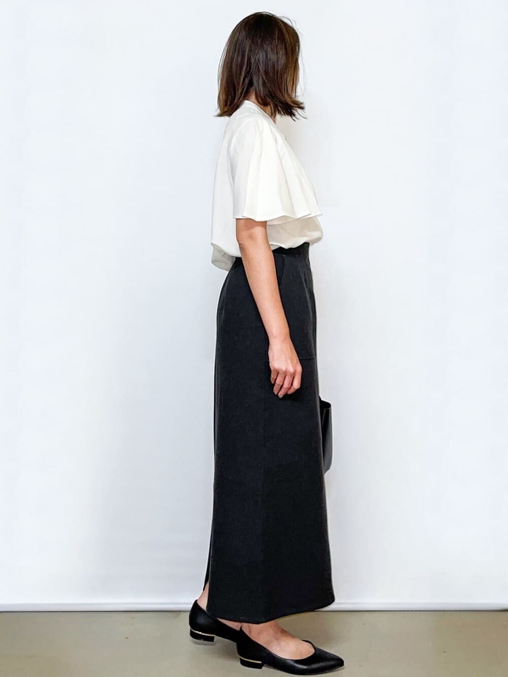 ホワイト系のシャツ/ブラウス、グレー系のスカート、ブラック系のトートバッグを着用したレディースの夏コーディネートの4枚目の写真