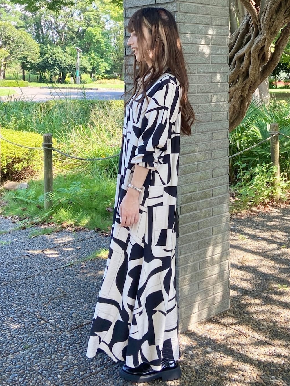 ベージュ系のワンピース、ブラック系のショルダーバッグを着用したレディースの秋コーディネートの3枚目の写真