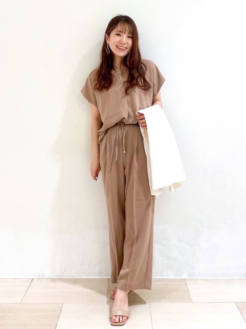 ベージュ系のシャツ/ブラウス、ベージュ系のサンダル、ホワイト系のカーディガン/ボレロを着用したレディースの春コーディネートの4枚目の写真