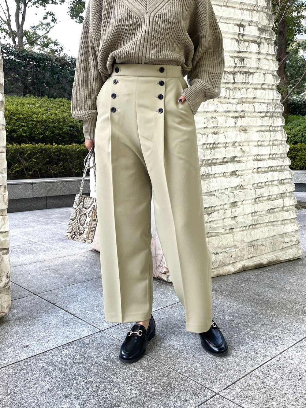 ベージュ系のニット/セーター、グリーン系のその他パンツ、ベージュ系のショルダーバッグを着用したレディースの冬コーディネートの3枚目の写真