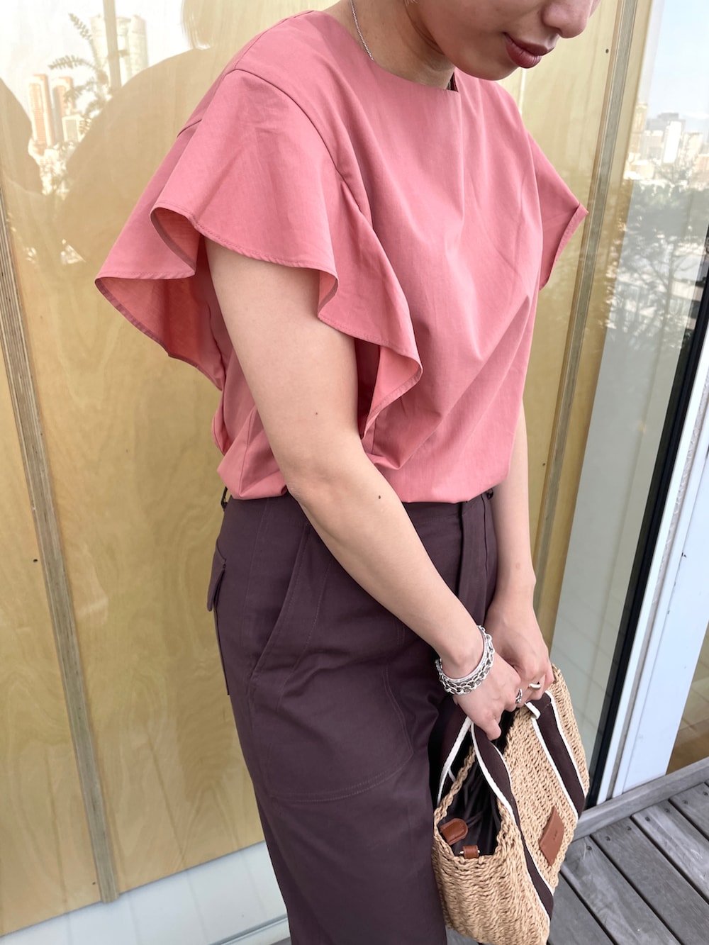 レッド系のシャツ/ブラウス、ブラウン系のその他パンツ、ブラウン系のトートバッグを着用したレディースの夏コーディネートの2枚目の写真