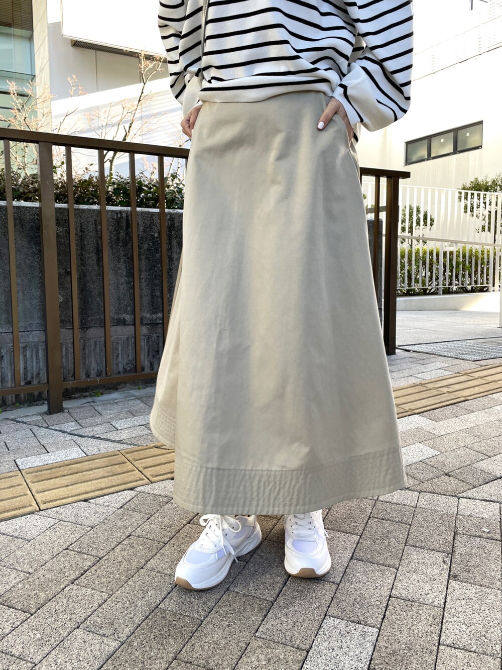 ブラック系のニット/セーター、ベージュ系のスカートを着用したレディースの冬コーディネートの2枚目の写真