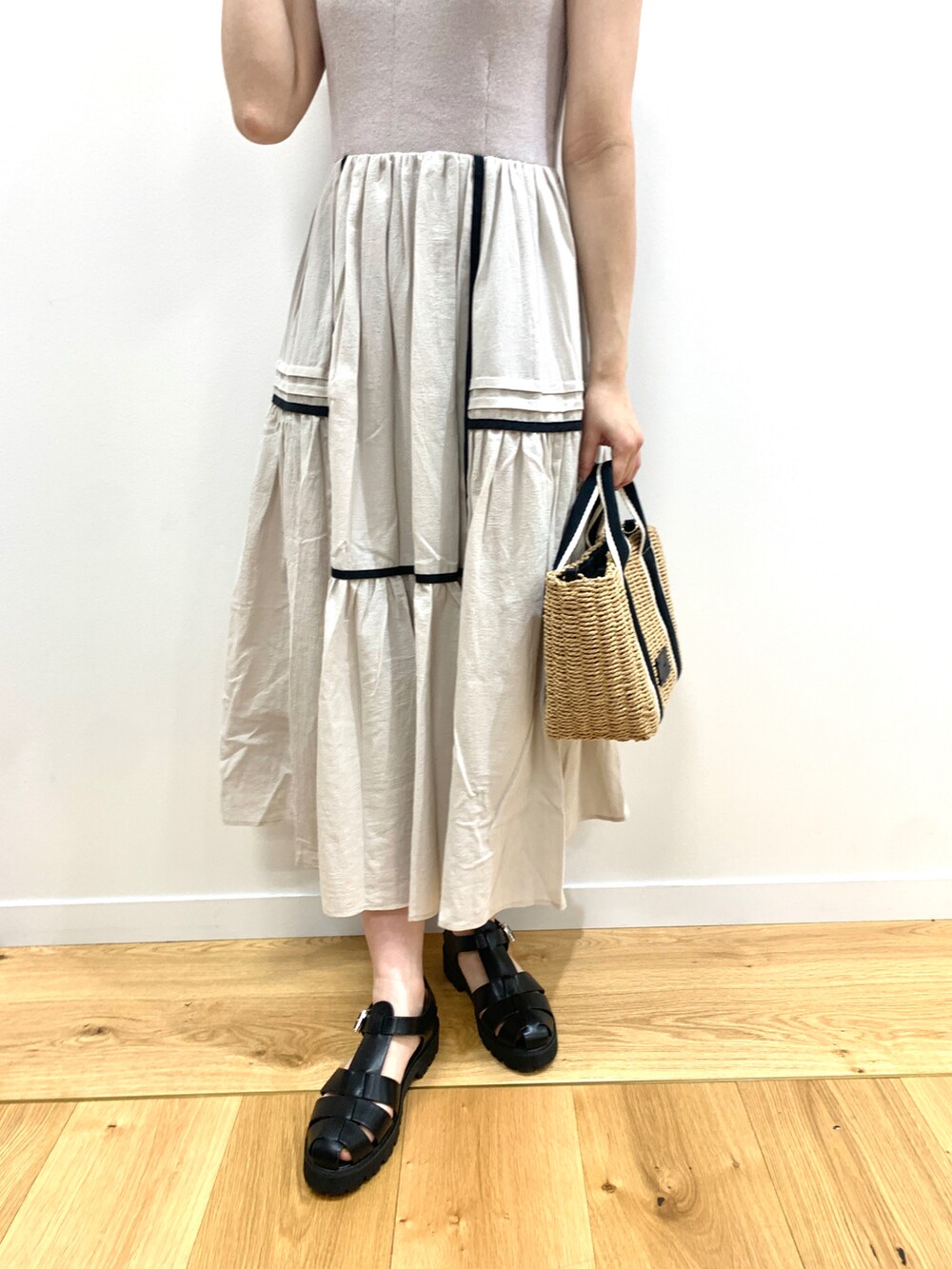 グレー系のワンピース、ブラック系のサンダル、ブラック系のトートバッグを着用したレディースの夏コーディネートの3枚目の写真