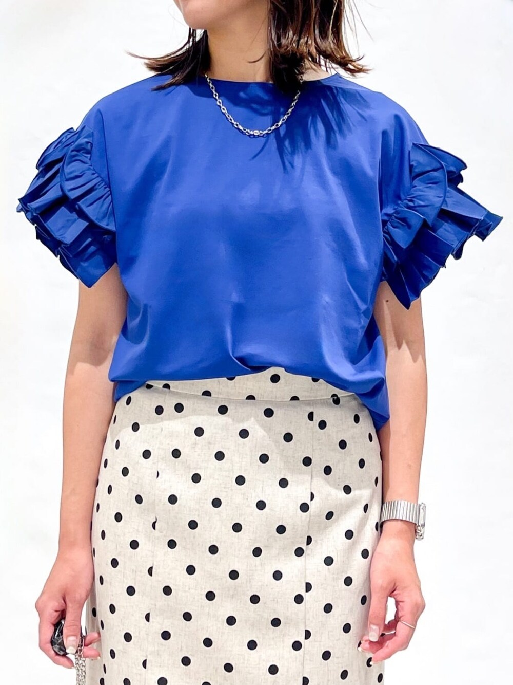 ベージュ系のスカート、ブラック系のショルダーバッグ、シルバー系のサンダルを着用したレディースの夏コーディネートの6枚目の写真