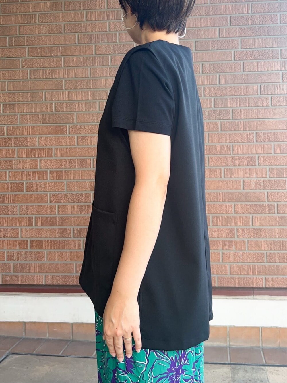 ブラック系のTシャツ/カットソー、ブラック系のベスト、グリーン系のその他パンツを着用したレディースの秋コーディネートの4枚目の写真