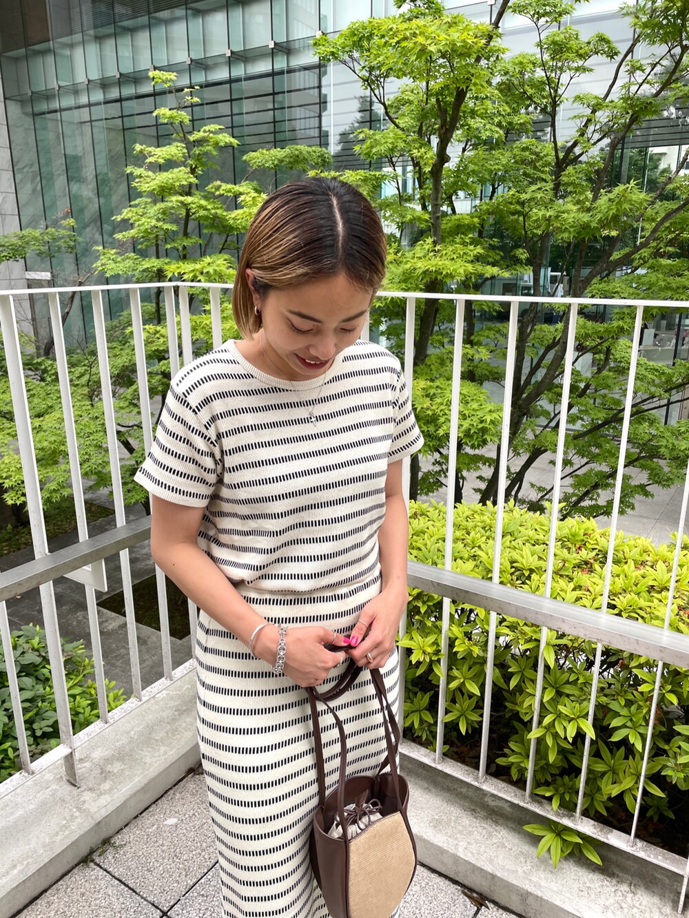 ホワイト系のTシャツ/カットソー、ホワイト系のスカート、ブラウン系のショルダーバッグを着用したレディースの夏コーディネートの3枚目の写真