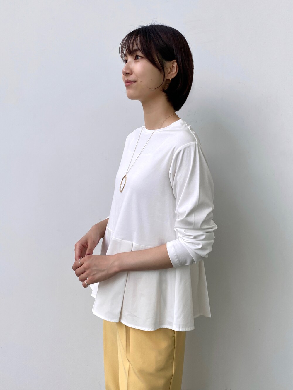 ホワイト系のTシャツ/カットソー、イエロー系のその他パンツ、ゴールド系のネックレスを着用したレディースの秋コーディネートの4枚目の写真