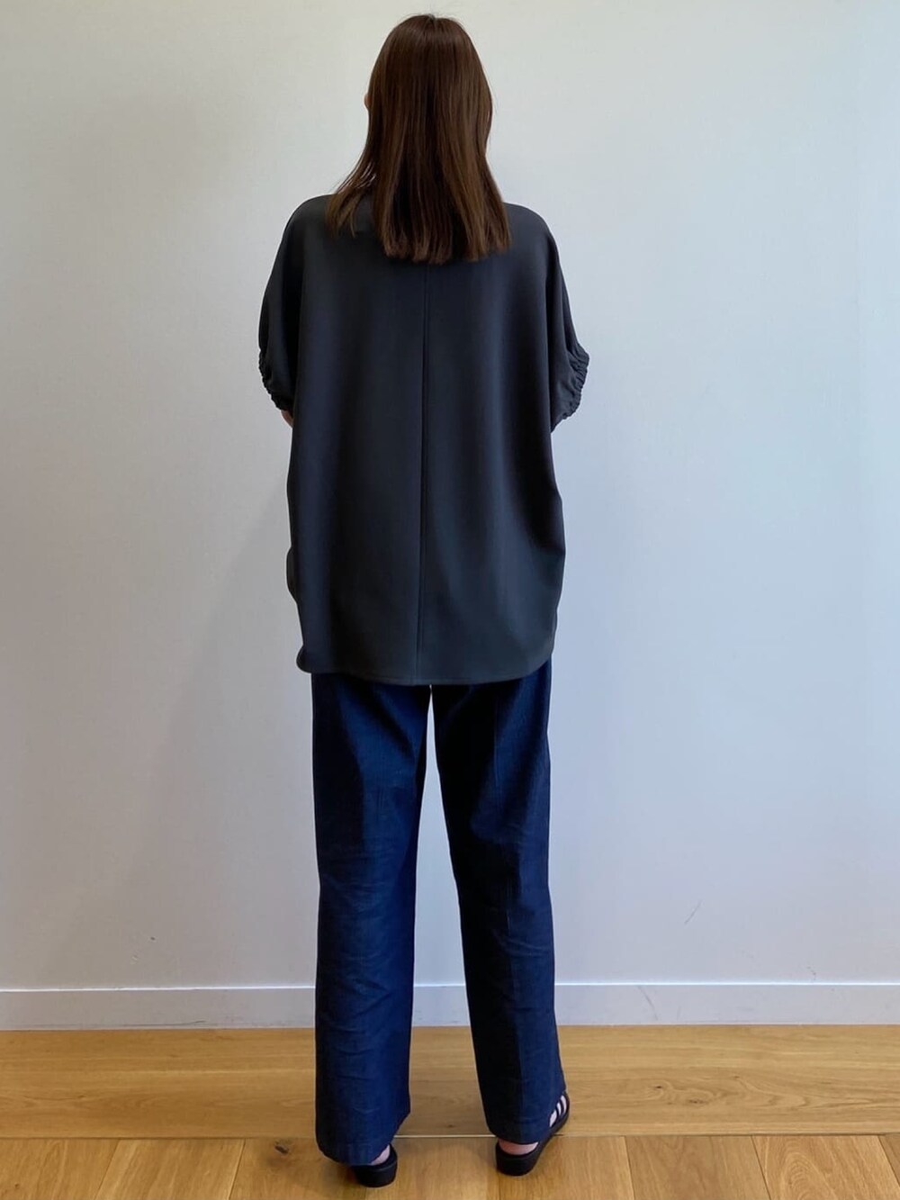 グレー系のTシャツ/カットソー、ブルー系のデニムパンツ、ブラック系のサンダルを着用したレディースの春コーディネートの5枚目の写真