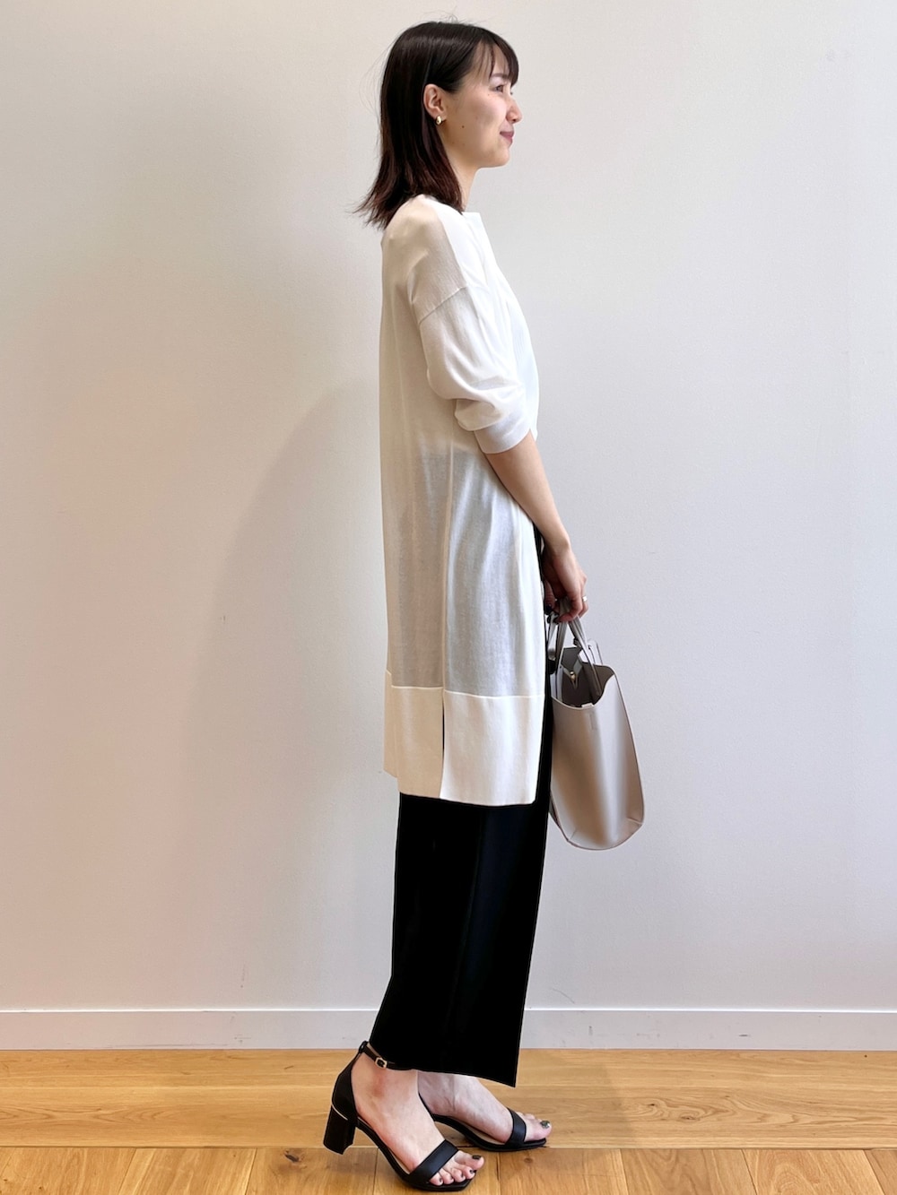 ブラック系のサンダル、ホワイト系のTシャツ/カットソー、ホワイト系のカーディガン/ボレロを着用したレディースの夏コーディネートの2枚目の写真