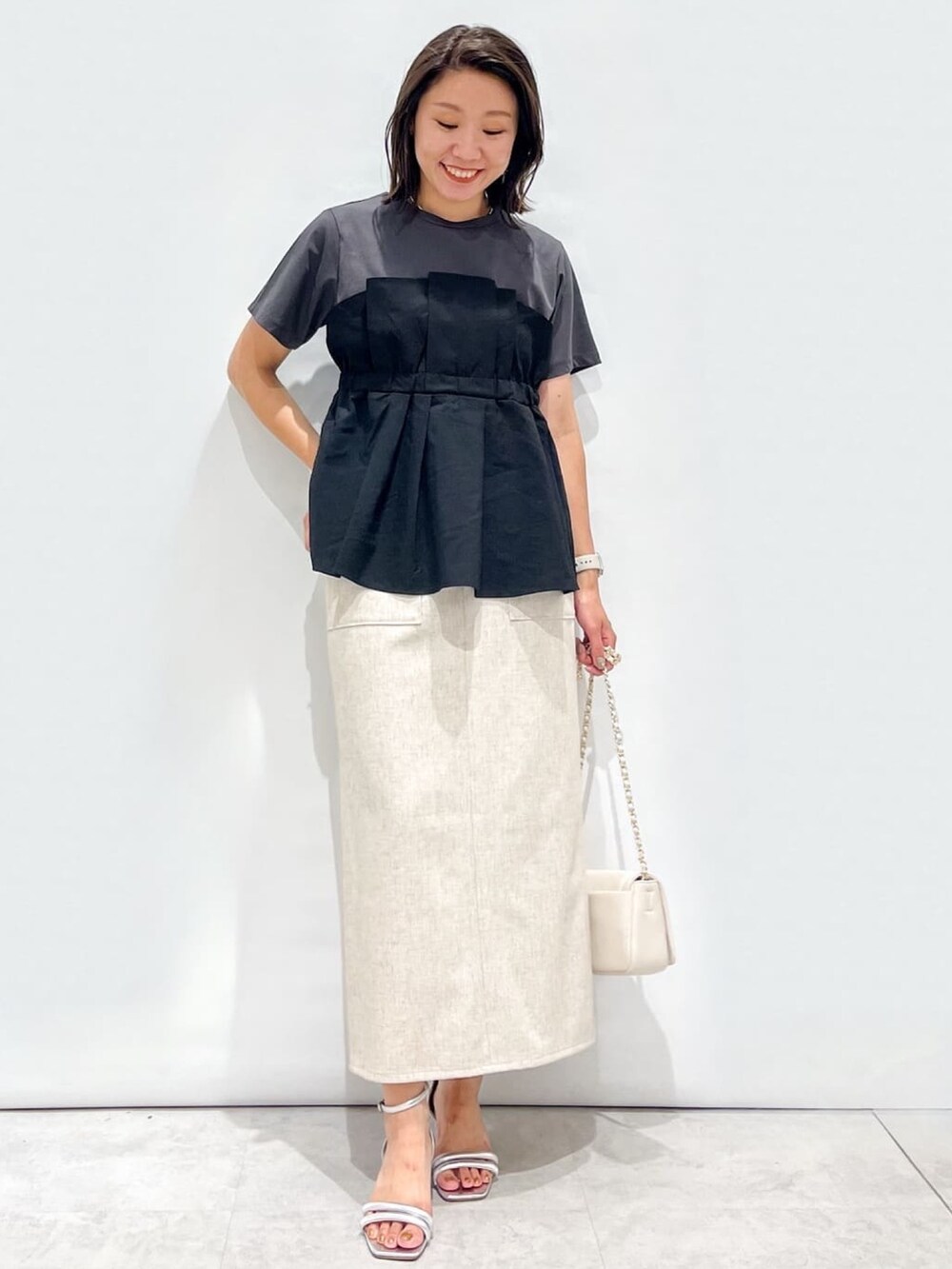 ブラック系のTシャツ/カットソー、ベージュ系のスカート、ホワイト系のショルダーバッグを着用したレディースの夏コーディネートの4枚目の写真