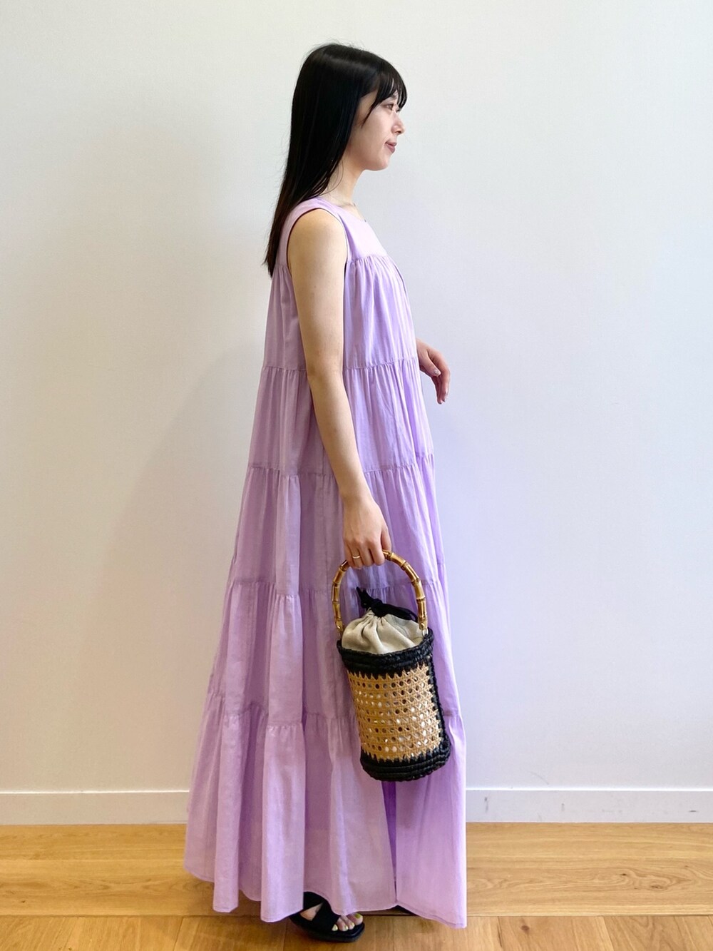 パープル系のワンピース、ブラック系のトートバッグ、ブラック系のサンダルを着用したレディースの夏コーディネートの3枚目の写真
