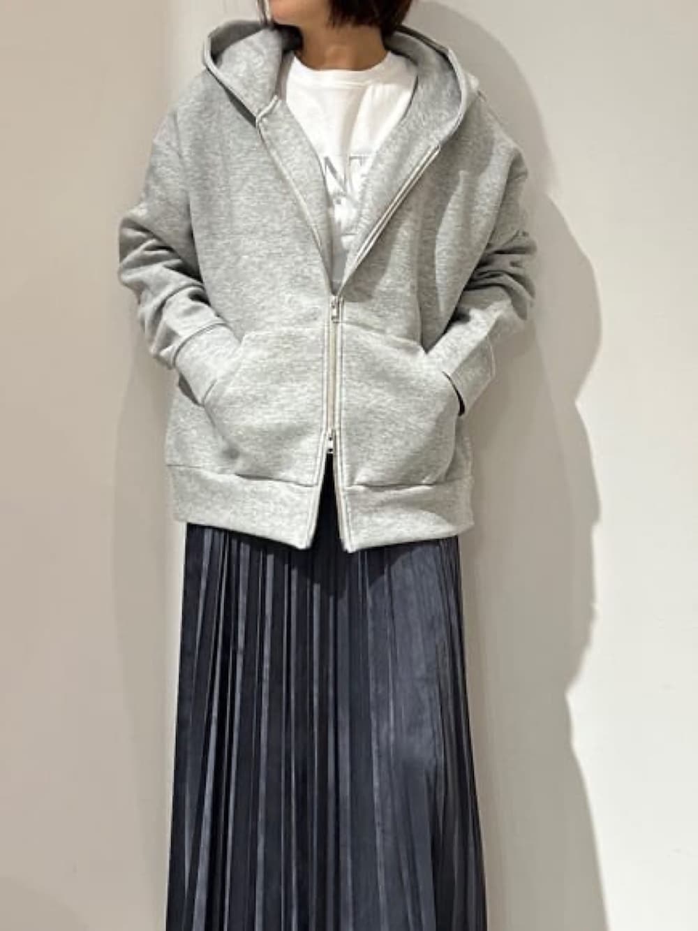 グレー系のスカート、ホワイト系のTシャツ/カットソー、グレー系のパーカーを着用したレディースの秋コーディネートの4枚目の写真